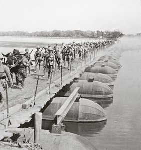 Section de mitrailleuses et infanterie traversant une rivière inondée par un pont de pontons